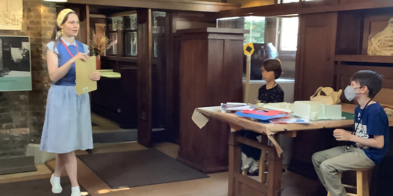 Trust educator greets students near the interior entryway to Wright’s studio