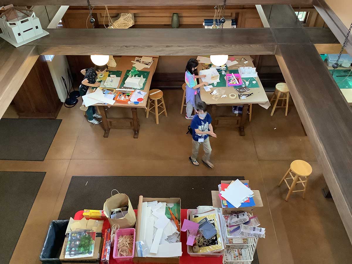 A view down into the studio space from the balcony above as campers continue on with their model making