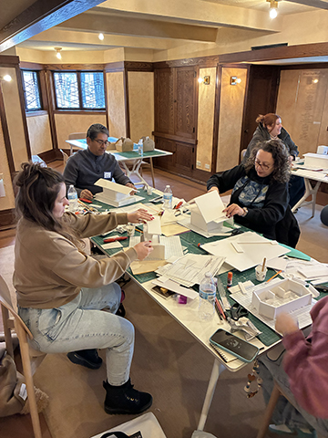 During a model building workshop in Robie House playroom, educators assemble the roofs of their Prairie style homes.