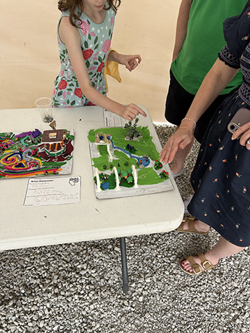 A camper points out an element of her model during the Final Showcase.