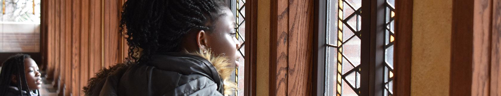 two students looking through art glass windows